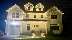 Short Hills NJ home with warm white C9 roofline lights, lit dormers and a lighted walkway