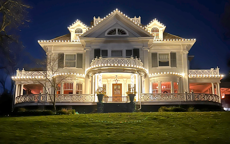 Historic Victorian in Short Hills NJ wrapped in professional Christmas lights along porch and gables
