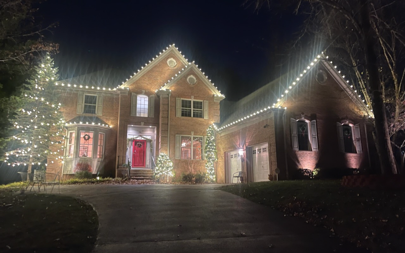 Brick Short Hills NJ home with roofline lights, decorated trees and holiday wreaths