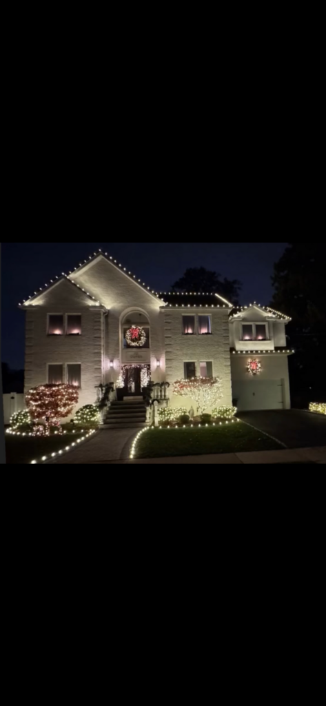 Short Hills NJ home with roofline lights, wreaths and fully lighted front landscaping