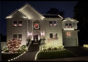 Short Hills NJ home with roofline lights, wreaths and fully lighted front landscaping